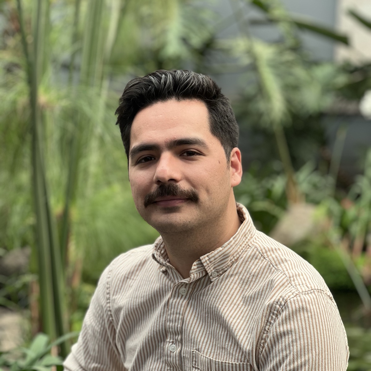 Alexis Meza, photographed outdoors among tall grasses and greenery